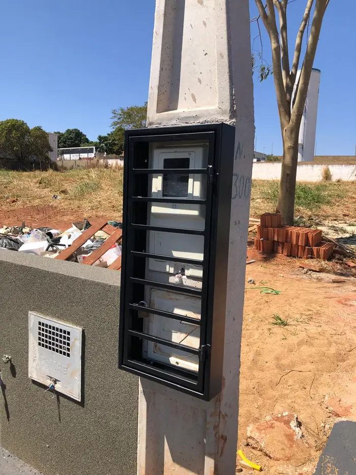 A mesma caixa de proteção fixada num poste de concreto à beira da estrada