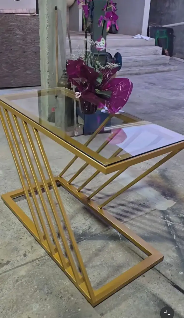 Detalhe da base dourada da mesa, mostrando a solda das barras no encontro dos losangos