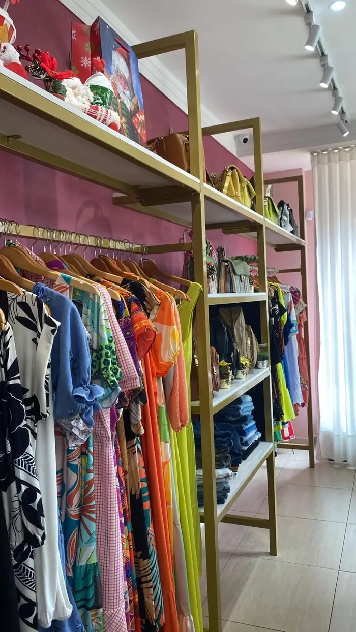 Araras e prateleiras metálicas montadas ao longo da parede da loja