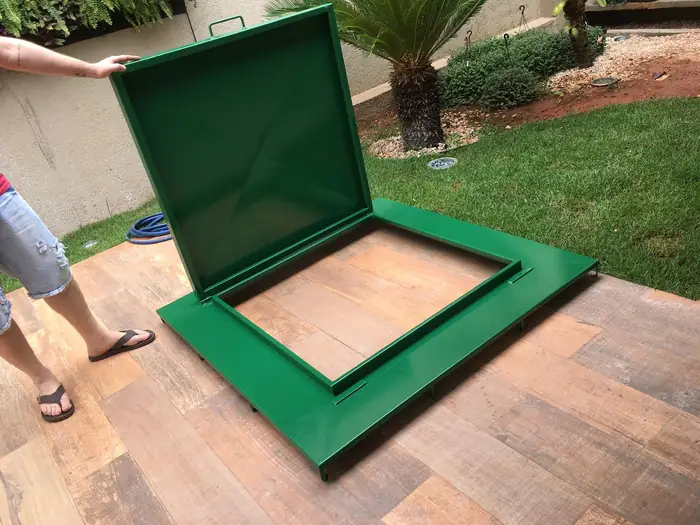 A mesma tampa aberta, mostrando a moldura metálica e o vão da casa de máquinas